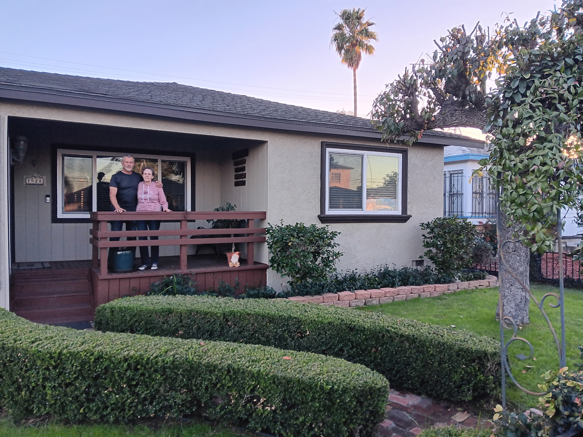 Happy homeowners in front of freshly painted home
